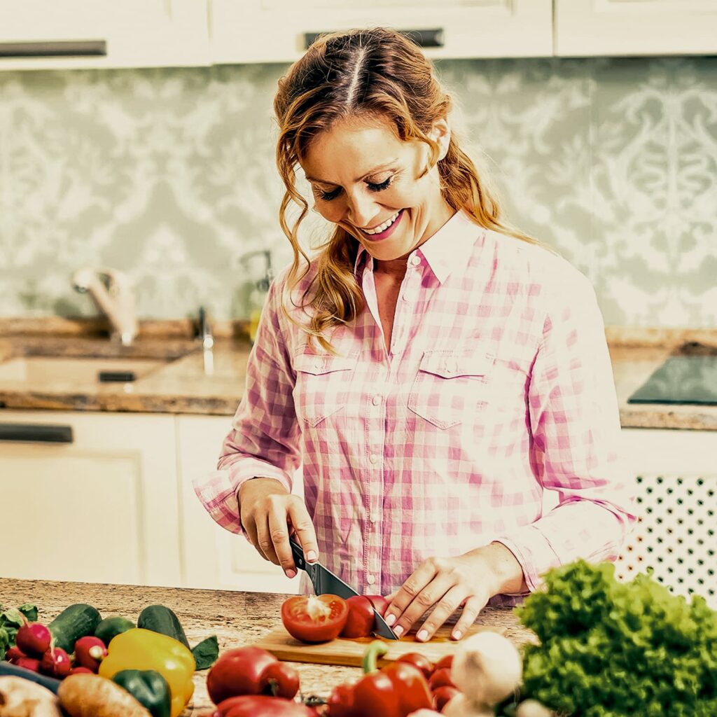 Woman cutting tomatoes with sharp chef knife